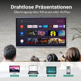 Personen sehen sich Inhalte auf einem großen interaktiven Display an, das kabellose Präsentationen über Miracast oder AirPlay zeigt. Auf dem Bildschirm sind Streaming-Apps wie Netflix, YouTube und Prime Video zu sehen. Unten werden Geräte wie Desktop, Laptop, Tablet und Smartphone als kompatible Quellen dargestellt.